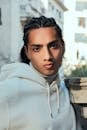 Portrait of a young man in a white hoodie, showcasing modern urban fashion style.