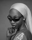 Stylish black and white portrait of a woman with sunglasses and traditional attire.